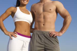 "close up of fit waist couple as weight loss and fitness concept, isolated on blue sky background"