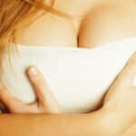 A woman with a bandage wrapped around her breasts after a breast augmentation.
