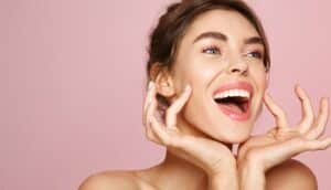 Woman smiling with hands on her face after FaceTite in Houston, TX